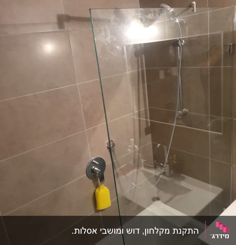 זכוכית מקלחון עם כתמי מים ותאורה חזקה